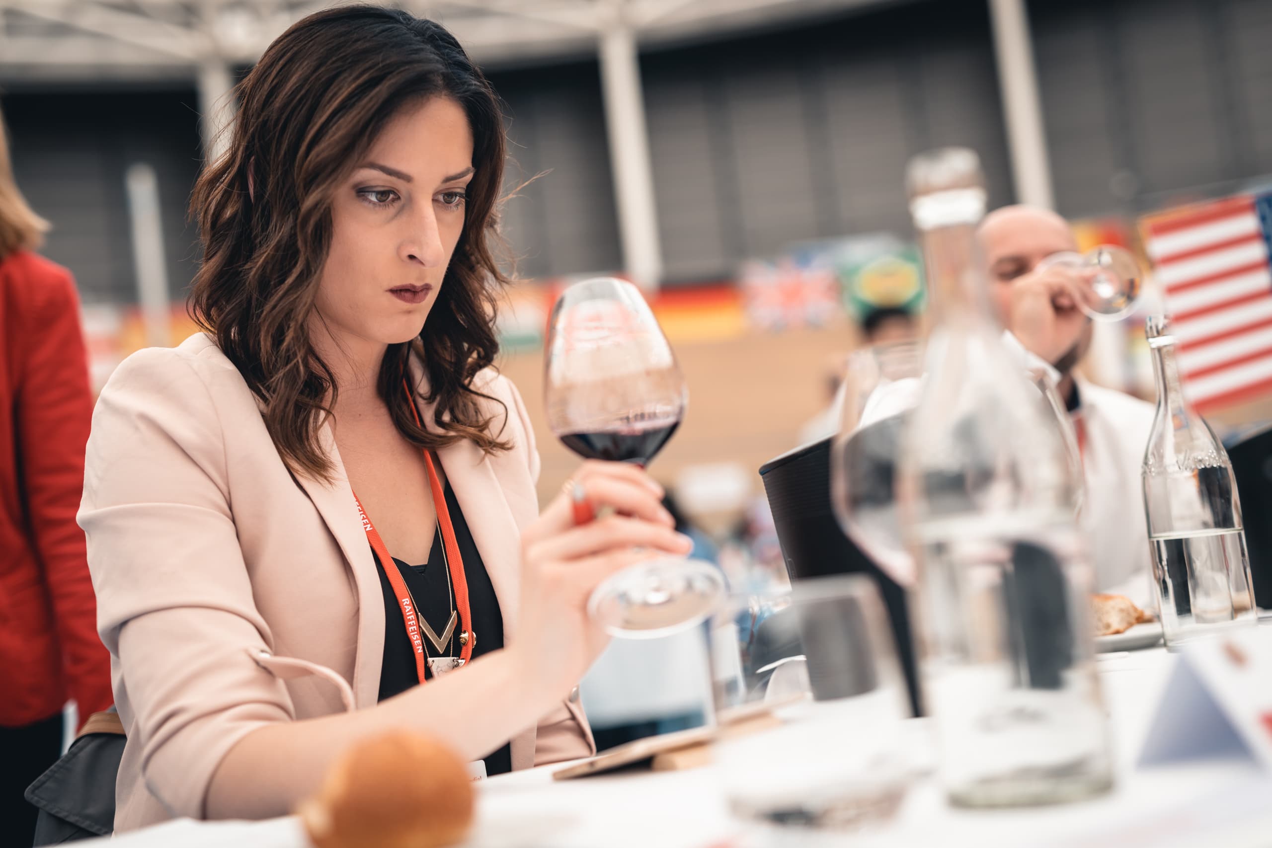 A woman inspecting a glass of red wine